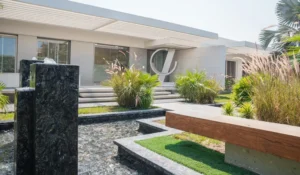 Modern building exterior with a water fountain and landscaped greenery.