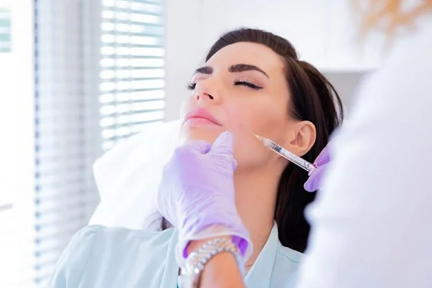 The doctor is injecting Dermal Filler into the patient’s Nasolabial folds