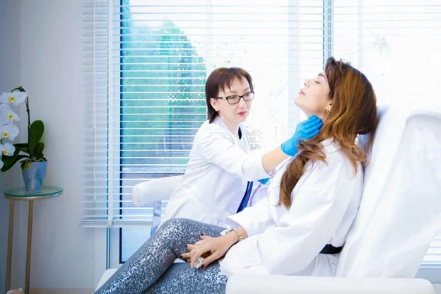 The doctor is examining the patient’s neck before determining the Dermal Fillers injection sites