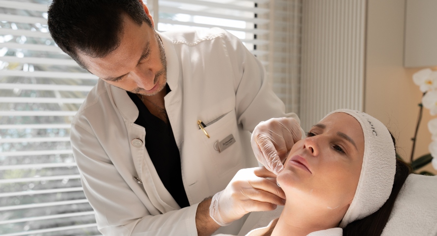 A dermatologist measuring facial proportions before applying dermal fillers.