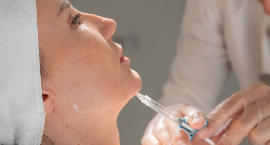 A patient undergoing dermal filler treatment to contour the jawline.