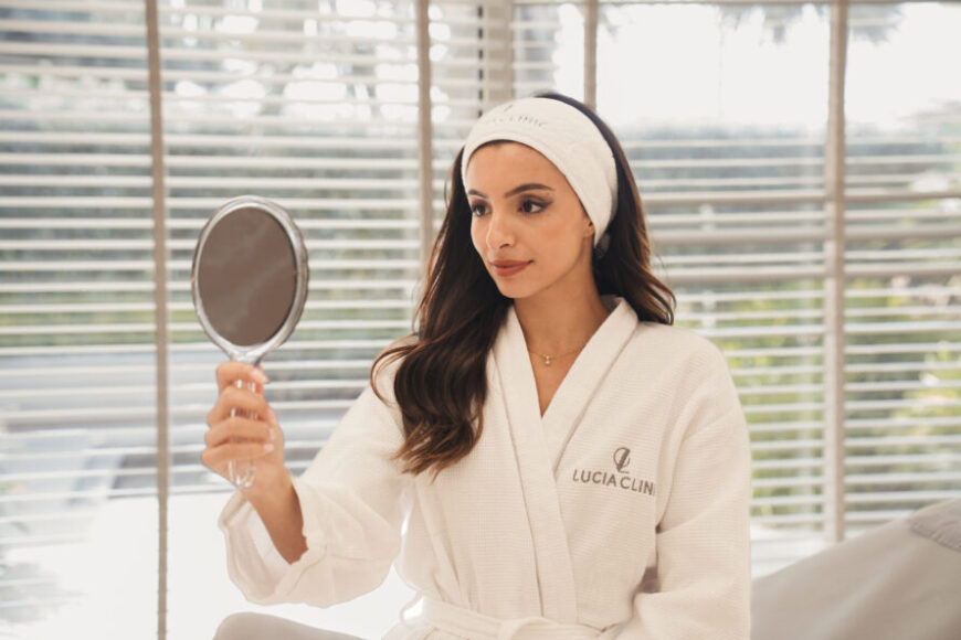 A woman looking at a mirror after a breast lift surgery.