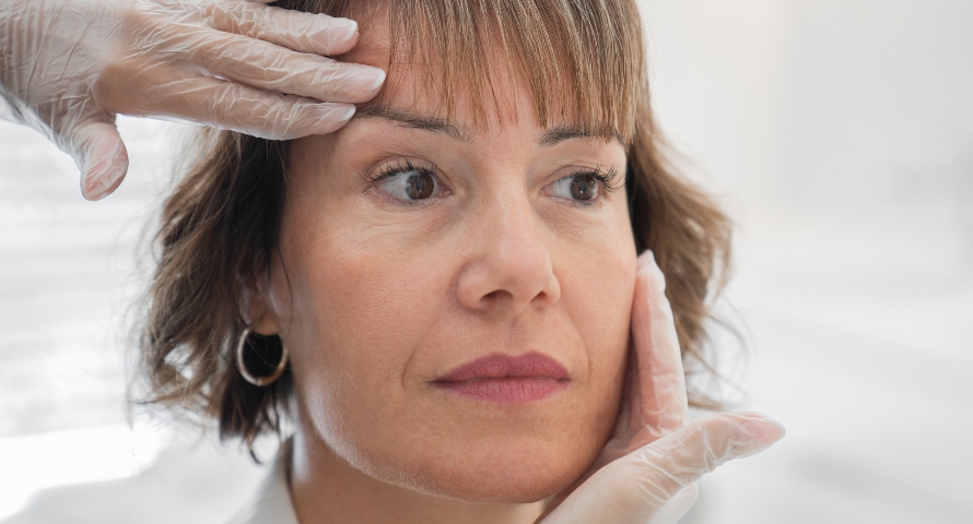 A woman undergoing facial assessment for plastic surgery options to achieve a more youthful look.