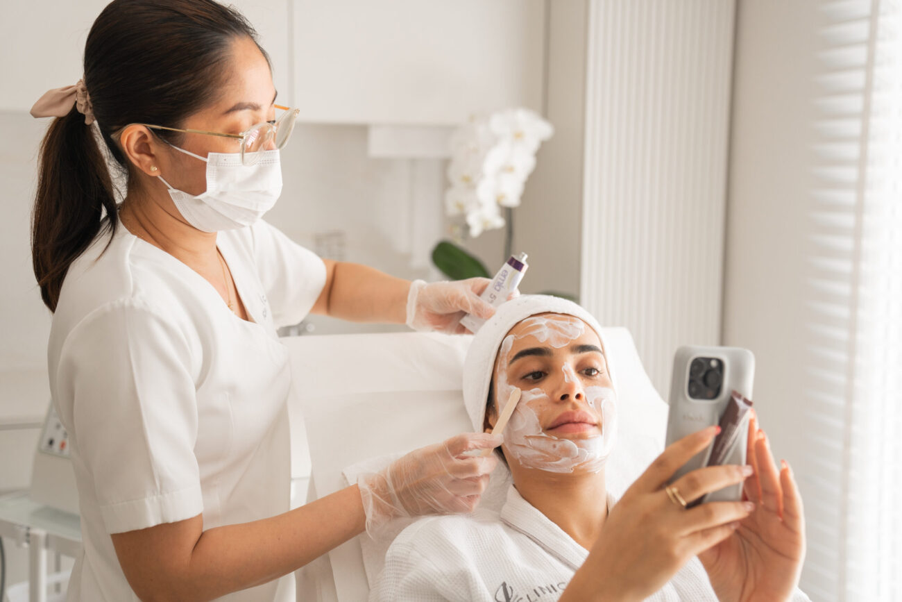 A woman looking at her phone while getting meta cell treatment Dubai