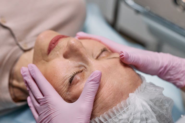A middle aged woman during a facial massage, representing top anti-aging tips