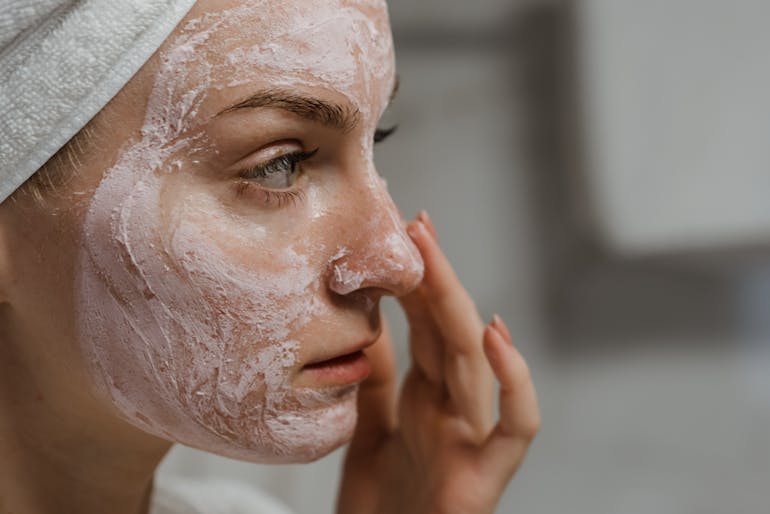 A woman exfoliates as one of the top anti-aging tips