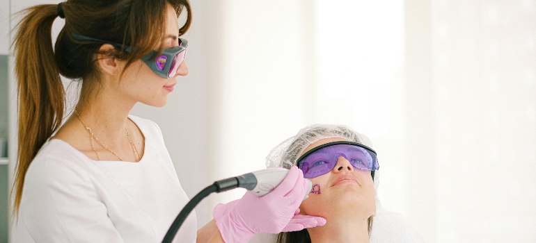 A woman in a cosmetic treatment performed by a dermatologist to repair sun damaged skin