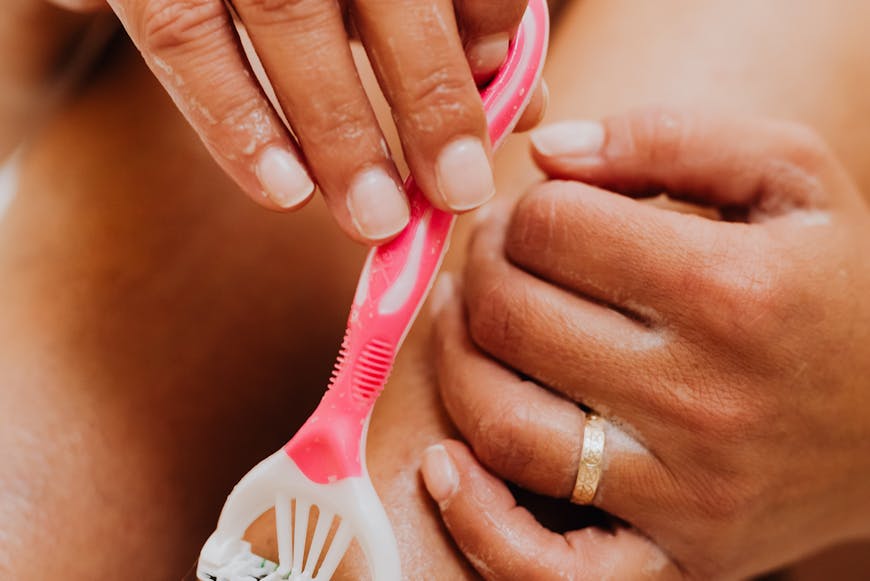 A woman shaving her legs and thinking about how to prevent and treat painful ingrown hairs