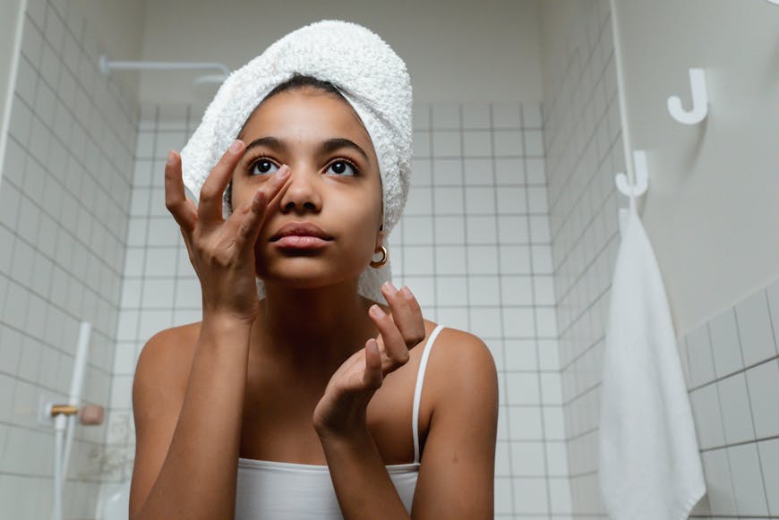 A woman putting skin care on her face