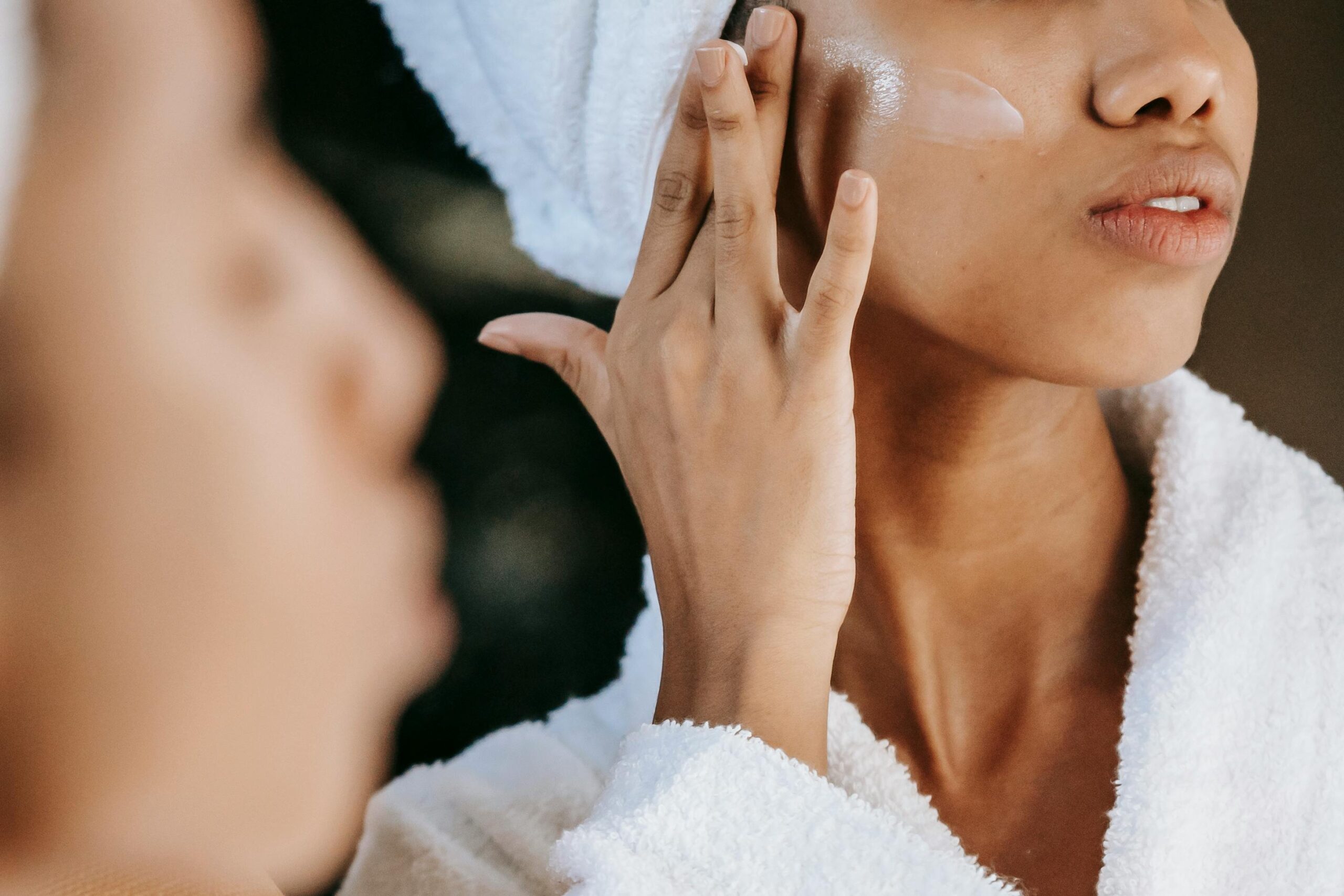 woman putting a cream on her cheek