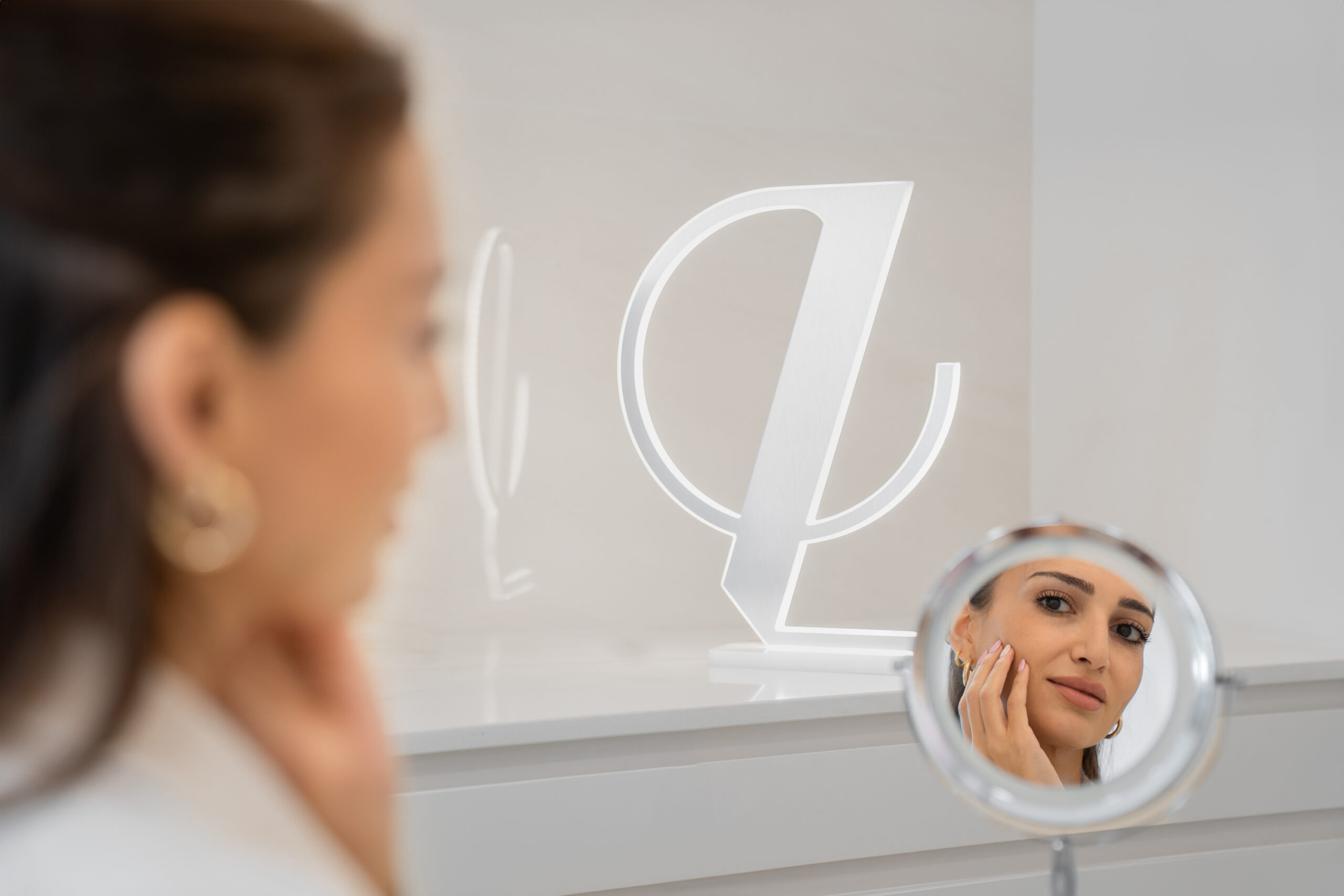 woman looking at a mirror at Lucia Clinic