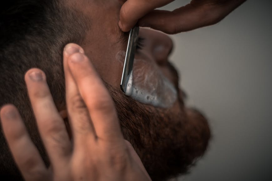 A man getting his beard shaved