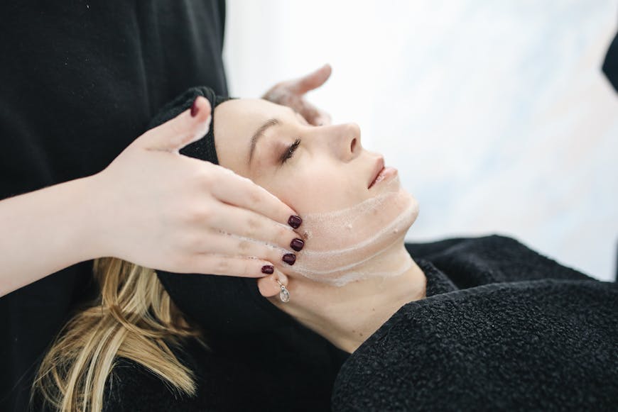 Woman with a black glasses, having ultrasonic skin-treatment in salon.