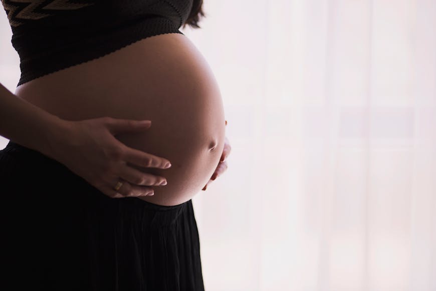 A woman holding her bully and considering tummy tuck after pregnancy