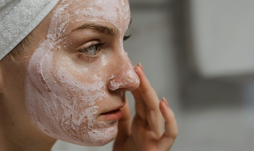 A woman applying a facial mask