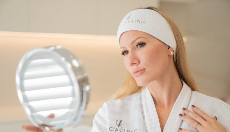 A woman looking at the mirror after subtle enhancements.