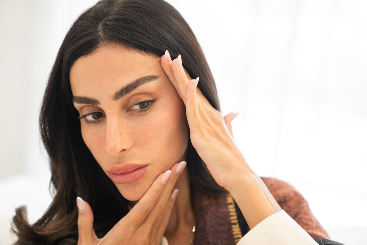 A woman looking at her face