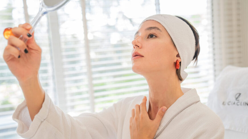 A woman looking at a mirror after surgery
