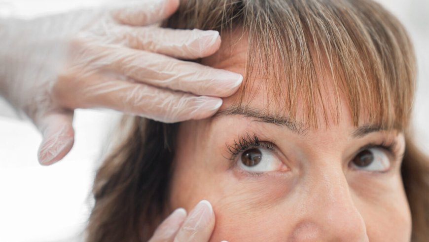 A doctor assessing the eyelids before a combined facial procedure
