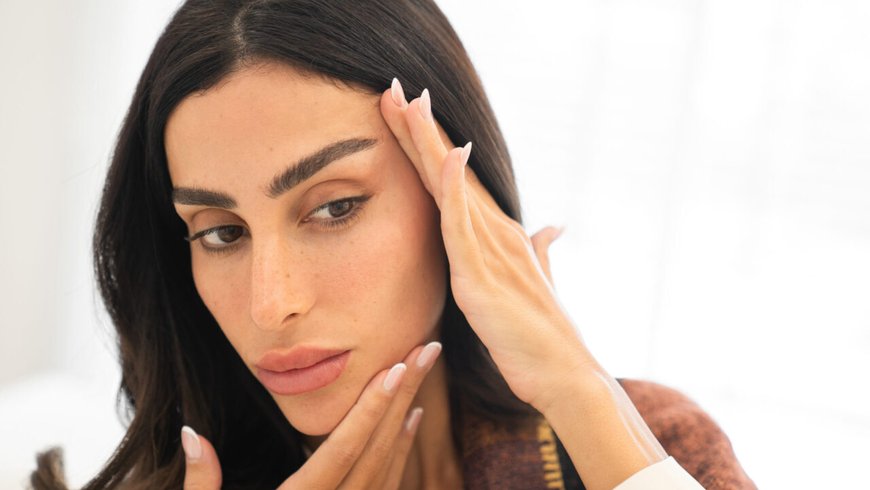 A woman assessing facial skin laxity before choosing a long-term treatment